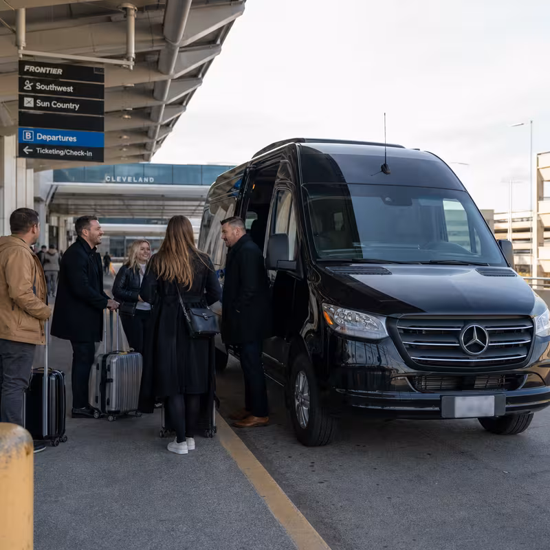 Group boarding a white charter bus for Airport Transportation transportation in Cleveland