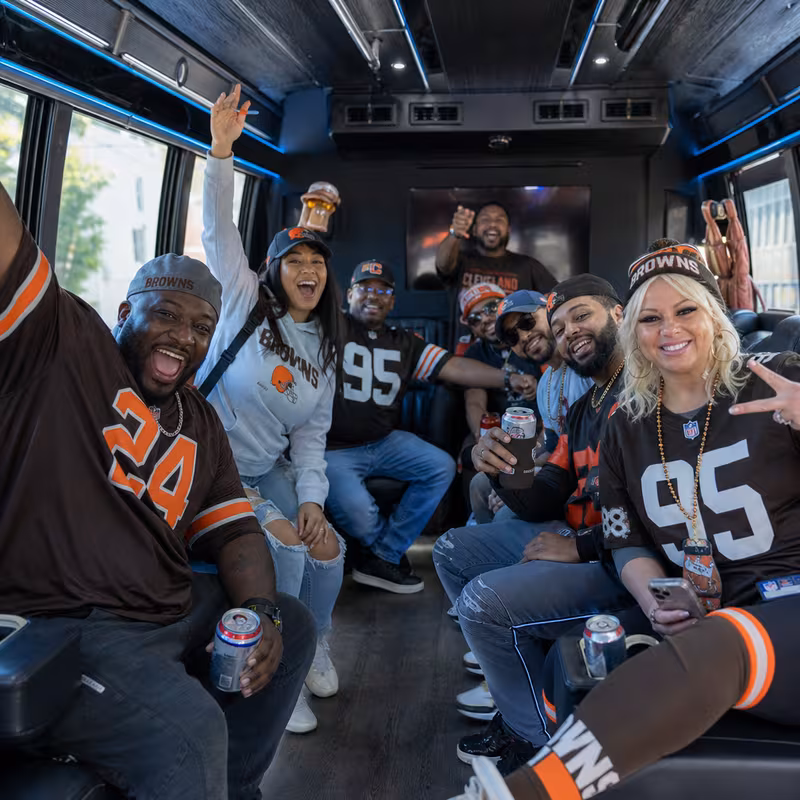 Group boarding a white charter bus for Sporting Event Transportation transportation in Cleveland